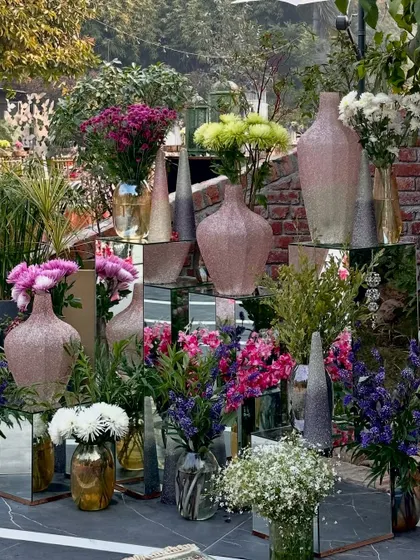 A modern floral setup with mirrored pedestals and glittery vases, perfect for a glamorous event.