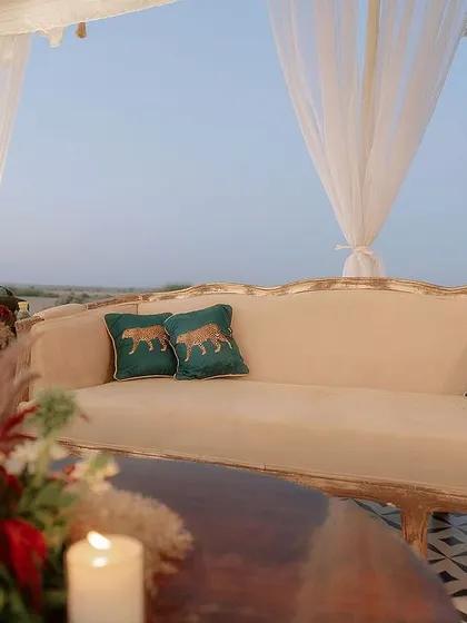 For this desert lounge, we chose an earthy, neutral palette with pops of color, like these custom tiger-embroidered cushions. The decor was designed to complement the stunning landscape, not compete with it.