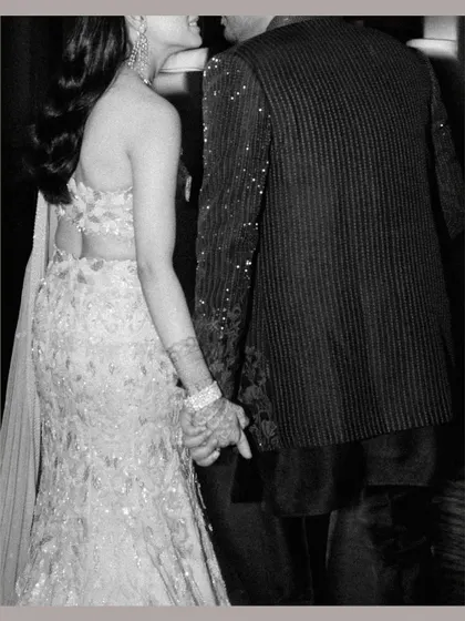 A close-up, black and white shot of the couple holding hands as they walk, a simple gesture full of meaning.