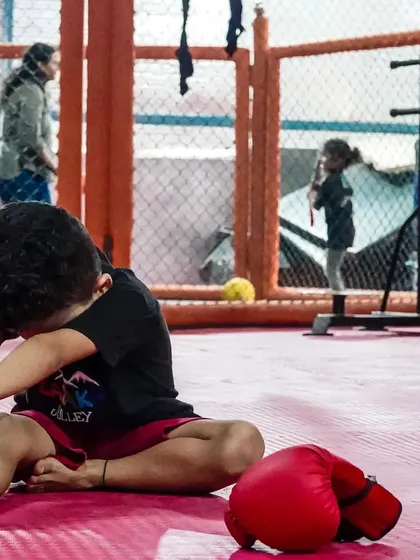 A young student stretches before his MMA class at our Sector 141 facility. Flexibility is a key component of our training for injury prevention and performance.