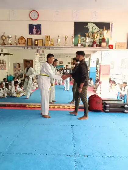 A student receives his yellow and green belt.