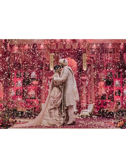 Tanya and Shivam are showered with petals after their varmala. This moment of celebration, with the couple at the center of a whirlwind of flowers and love, is a classic and beautiful wedding memory.