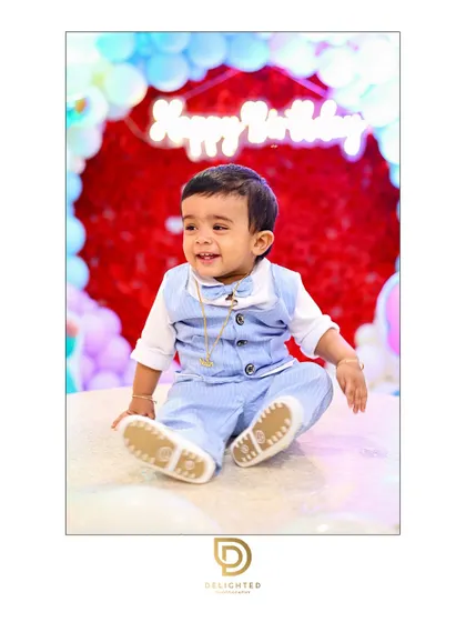 A little prince celebrates his first birthday with a big smile, surrounded by festive balloons. This photo highlights my approach to capturing the pure joy of children's parties.