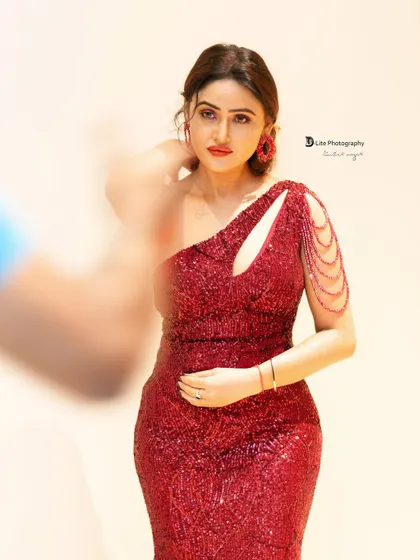A glamorous shot of actress Sony Charishta in a sparkling red gown. The creative use of motion blur adds an artistic touch to this fashion portrait.