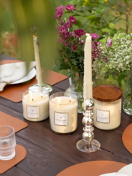 The warm light from our soy wax jar candles and classic tapers illuminates an elegant outdoor table setting. Mixing different candle heights and styles adds depth and visual interest to your decor.