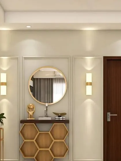This elegant entryway features a honeycomb-patterned console table and a simple round mirror. The warm wall sconces on either side create a balanced and welcoming composition.