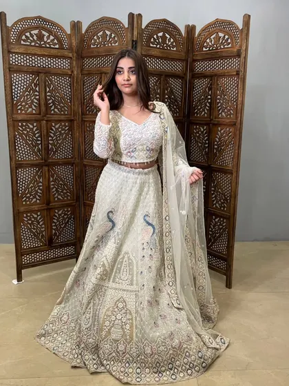 This off-white lehenga with intricate peacock embroidery is a masterpiece of craftsmanship.