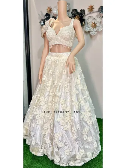 A full-length view of the ivory floral lehenga, showing the beautiful volume of the skirt and the delicate 3D flowers. This is a truly romantic and modern choice for any wedding event.