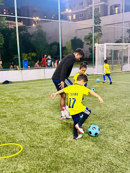 A coach demonstrates the correct technique for a footwork drill. Proper guidance is essential for our young players to develop good habits from the start.