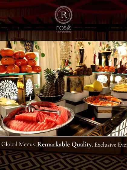 A buffet featuring a variety of fresh fruits, including sliced watermelon, pineapple, and persimmons. We believe in providing remarkable quality through global menus and the freshest ingredients.