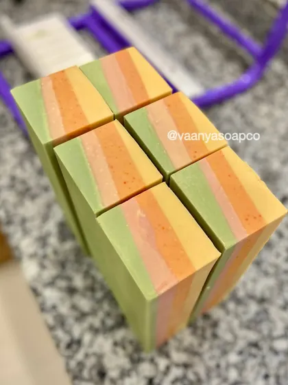 A top-down view of our freshly cut Tropical Escape soap bars. The layers of green, pink, orange, and yellow look like a tropical sunset.