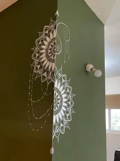 This semi-mandala was uniquely designed to wrap around a corner. The intricate white details on the olive green wall create a beautiful and continuous piece of art that flows from one space to another.
