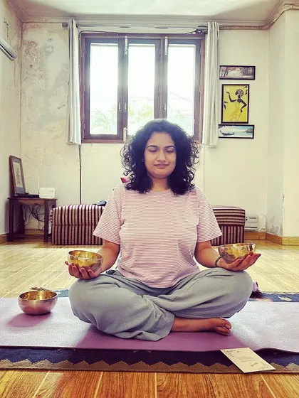 A student holding two small Tibetan bowls during a meditation session. Connecting with the bowls directly can be a powerful and personal experience.