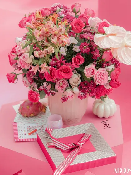 Another detail shot of the 'Gulabi Haldi' decor, with pink and white floral arrangements, dragon fruit, and custom-designed favor boxes, showing a meticulous attention to detail.