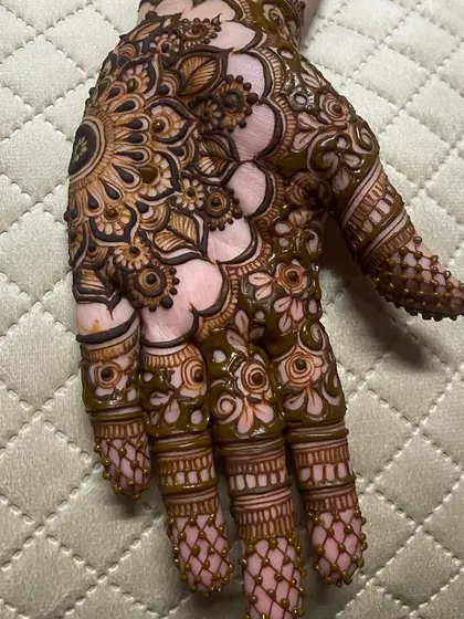 A close-up shot of the intricate finger work and the detailed shading within the mandala.