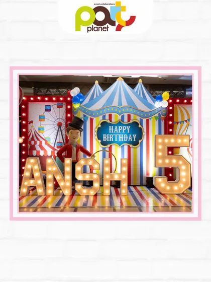 A classic circus-themed birthday stage with a big top backdrop, marquee letters, and a ringmaster prop for the perfect photo op.