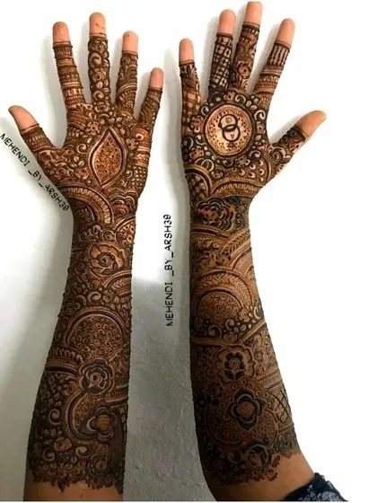 A full view of a custom bridal design. One palm features the couple's initials inside a circle, while the other has a more traditional pattern for a balanced look.