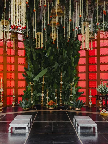 The inner sanctum of the mandap, where a wall of lush banana leaves and traditional brass lamps create a sacred space for the wedding rituals. This design focuses on bringing natural, auspicious elements to the forefront.