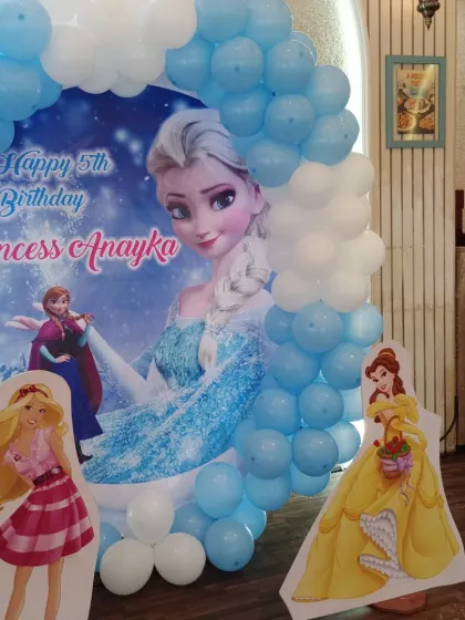 Another angle of the Frozen theme decor, showing the character cutouts of Barbie and Belle alongside the main backdrop.