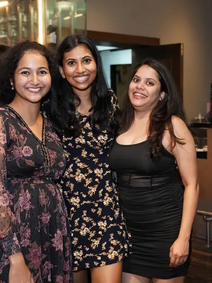 Three friends enjoying the night, posing together for a picture. It's a great place to socialize and meet new people.