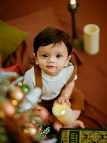 A close up of this adorable baby enjoying the Christmas magic. We focus on capturing their curious expressions and tiny details, making these festive portraits extra special for the family.