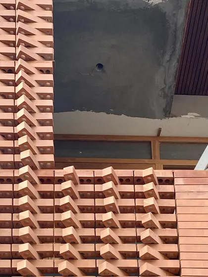 The 'Brick Weave House' facade under construction, showing the intricate pattern taking shape.