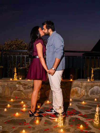 A passionate kiss surrounded by candles and rose petals. This is the epitome of a romantic pre-wedding photo.