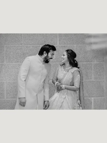 A sweet, candid moment between the couple, sharing a look and a smile, captured in timeless black and white.