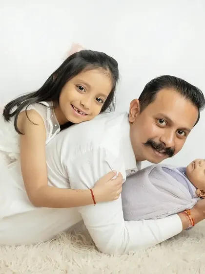 A proud father with his two angels. The older sister's happy smile says it all.