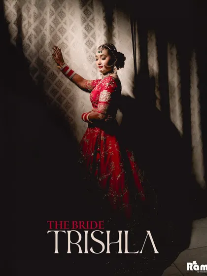 An artistic and dramatic portrait of the bride, "Trishla." The use of shadow and light creates a powerful silhouette, highlighting her pose and adding a touch of mystery and elegance to her bridal look.