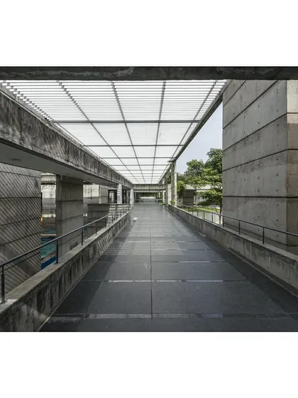 A view along the elevated walkway of the sports center, overlooking the swimming pool. The walkway provides a key circulation path and offers framed views of the activities below.