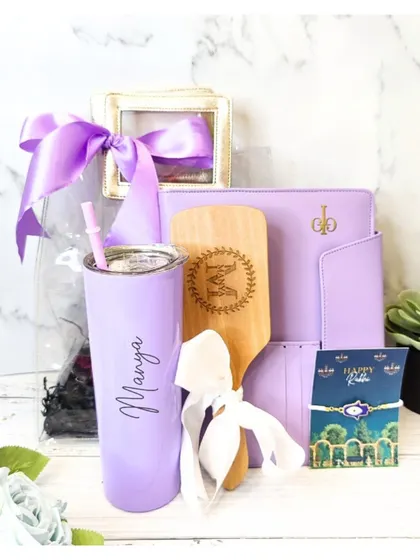 This vibrant lilac Rakhi hamper for a sister includes a personalized tumbler, a custom hairbrush, and a matching pouch, making it a fun and stylish gift.