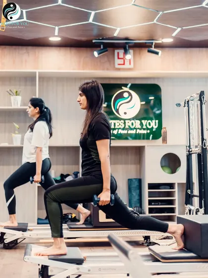 Dumbbell lunges on the Reformer add a strength-training element to a classic Pilates move. This full-body exercise tones the legs, glutes, and arms all at once.