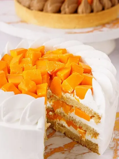 The inside of a layered mango cake, revealing the fresh fruit within. We capture these details to showcase the quality and deliciousness of your products.