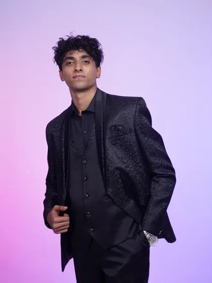 A full-length shot of the black tuxedo. The three-piece suit is impeccably tailored for a sharp, sophisticated look.