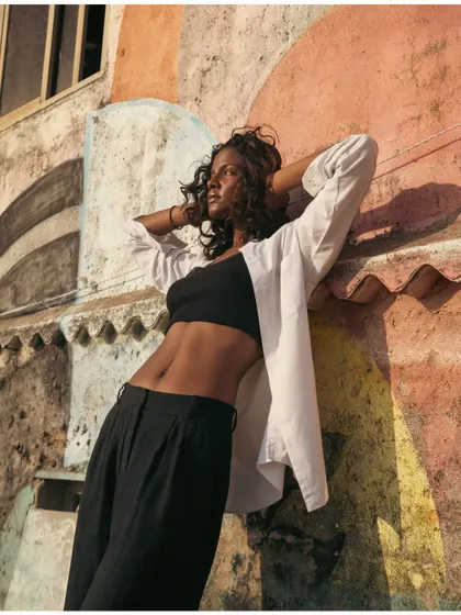 A different angle of the model against the graffiti wall, showcasing her toned physique and the interesting textures of the location.