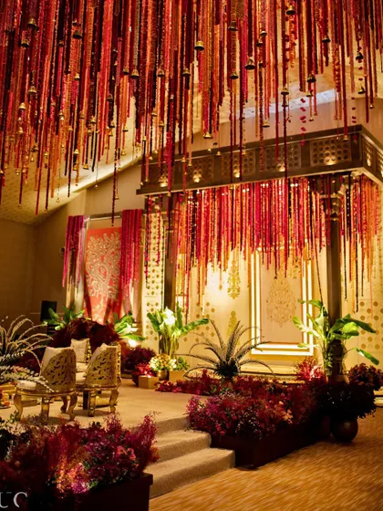 A close-up of the pillarless mandap, showcasing the thousands of flowers strung together to create a cascading ceiling. The little details, like the tiny bells, add a delicate sound and movement to the design.