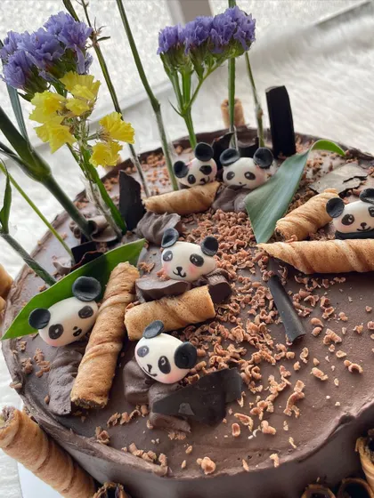 A close-up of the adorable, tiny fondant pandas on this chocolate cake.
