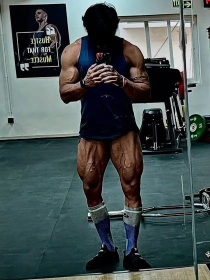 A full-body shot in the gym, displaying the results of a balanced training program. Strong legs, a lean core, and a powerful upper body.