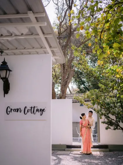A couple poses outside one of the 'Green Cottages' at Backyard. These private, air-conditioned rooms are perfect for getting ready or taking a quiet moment during your event.