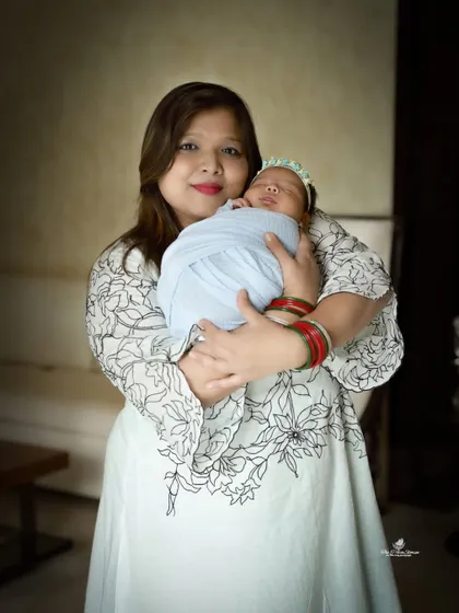 A classic mother and newborn portrait. The mother's gentle hold and loving expression perfectly capture the joy of new motherhood.