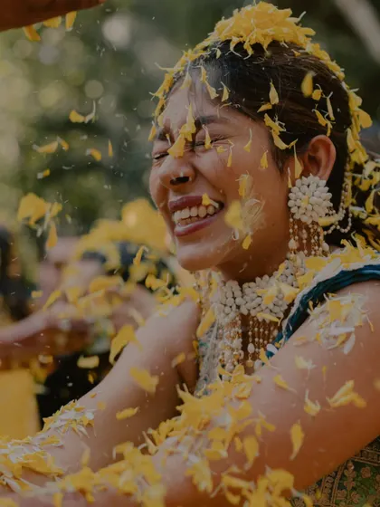 The pure, uninhibited laughter of the bride as she's covered in flower petals during her Haldi. These are the candid shots that truly show the spirit of the celebration.