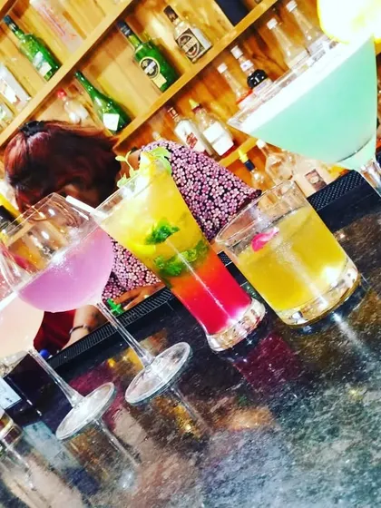 A rainbow of cocktails lined up on the bar. We can create a full custom menu with a variety of colors and flavors to match your party's theme.