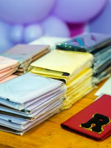 Stacks of colorful passport holders ready to be personalized at a creative party activity station.