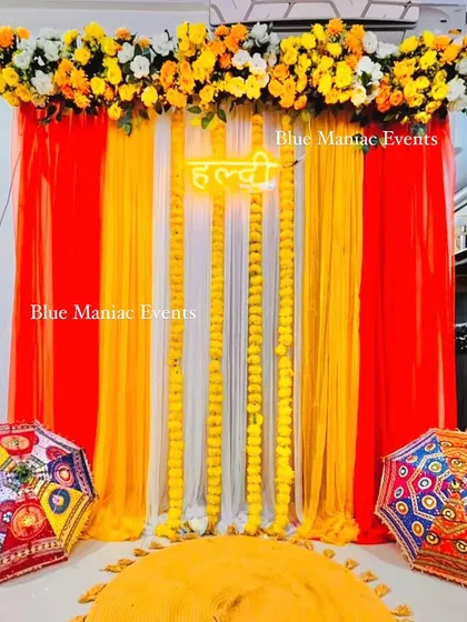 Another view of the red and yellow Haldi backdrop, perfect for small home functions.
