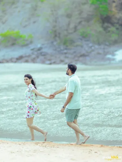 A playful shot of a couple running along the river's edge, their happiness evident in their smiles and movement.