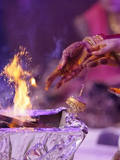 Hands offering prayers to the sacred fire. This detailed shot captures the essence of the havan ceremony, focusing on the ritual and its spiritual significance.