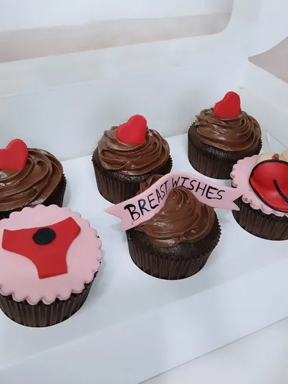 A box of naughty-themed cupcakes with "Breast Wishes" for the bride-to-be.