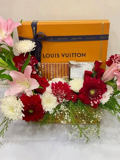 A simple yet elegant floral gift hamper perfect for any corporate occasion. This version features a Louis Vuitton box surrounded by soft pink lilies and red and white chrysanthemums.