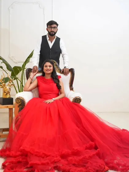 Regal and radiant in red. The bride is the epitome of elegance in this vibrant red ball gown with a ruffled trail, creating a powerful and classic pre-wedding portrait.